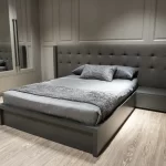 Modern genç odası tasarımı; gri başlıklı yatak, şık komodin ve aynalı gardırop ile sade ve estetik dekorasyon.